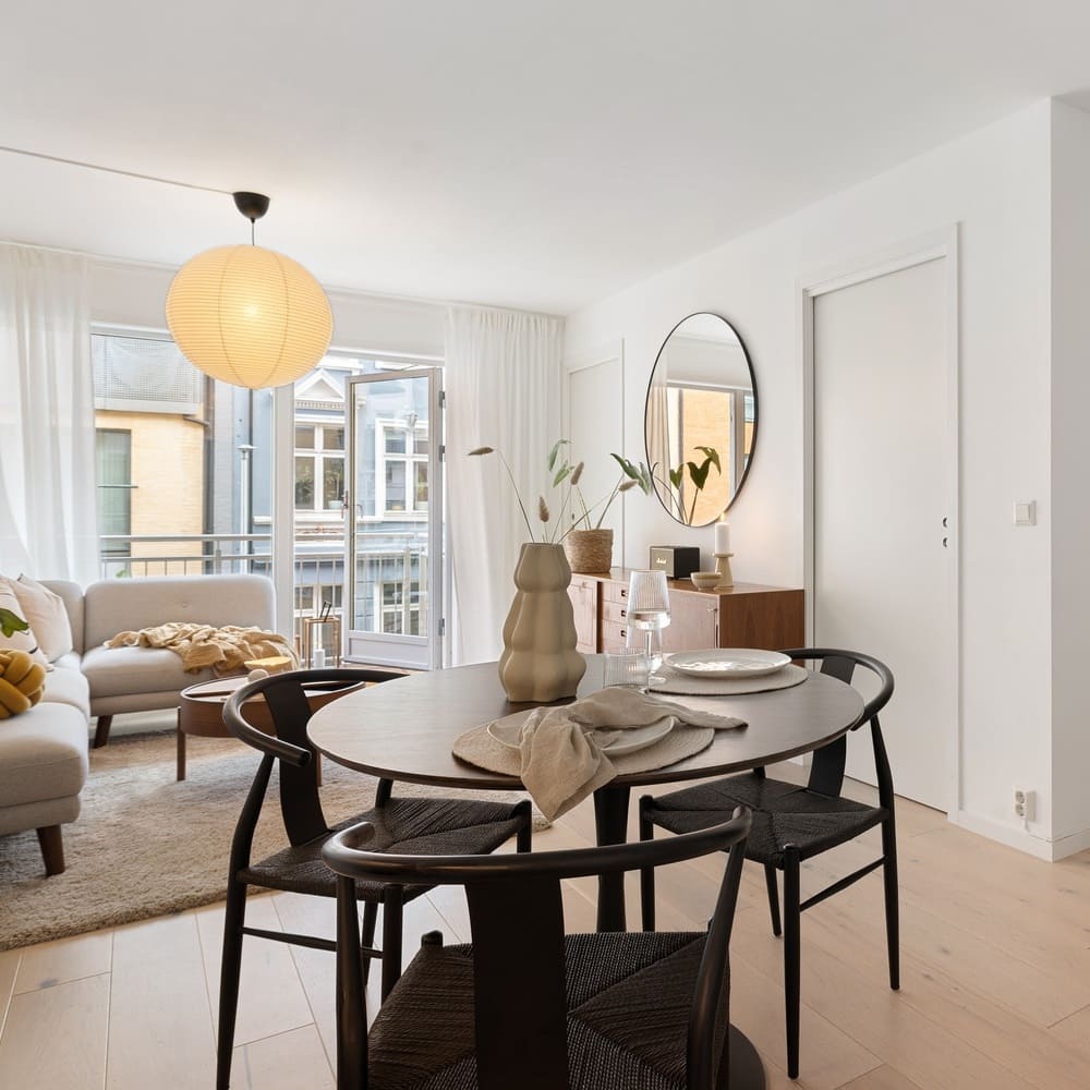 Stylish contemporary living room with inviting lighting, a fireplace, modern furniture, and large windows