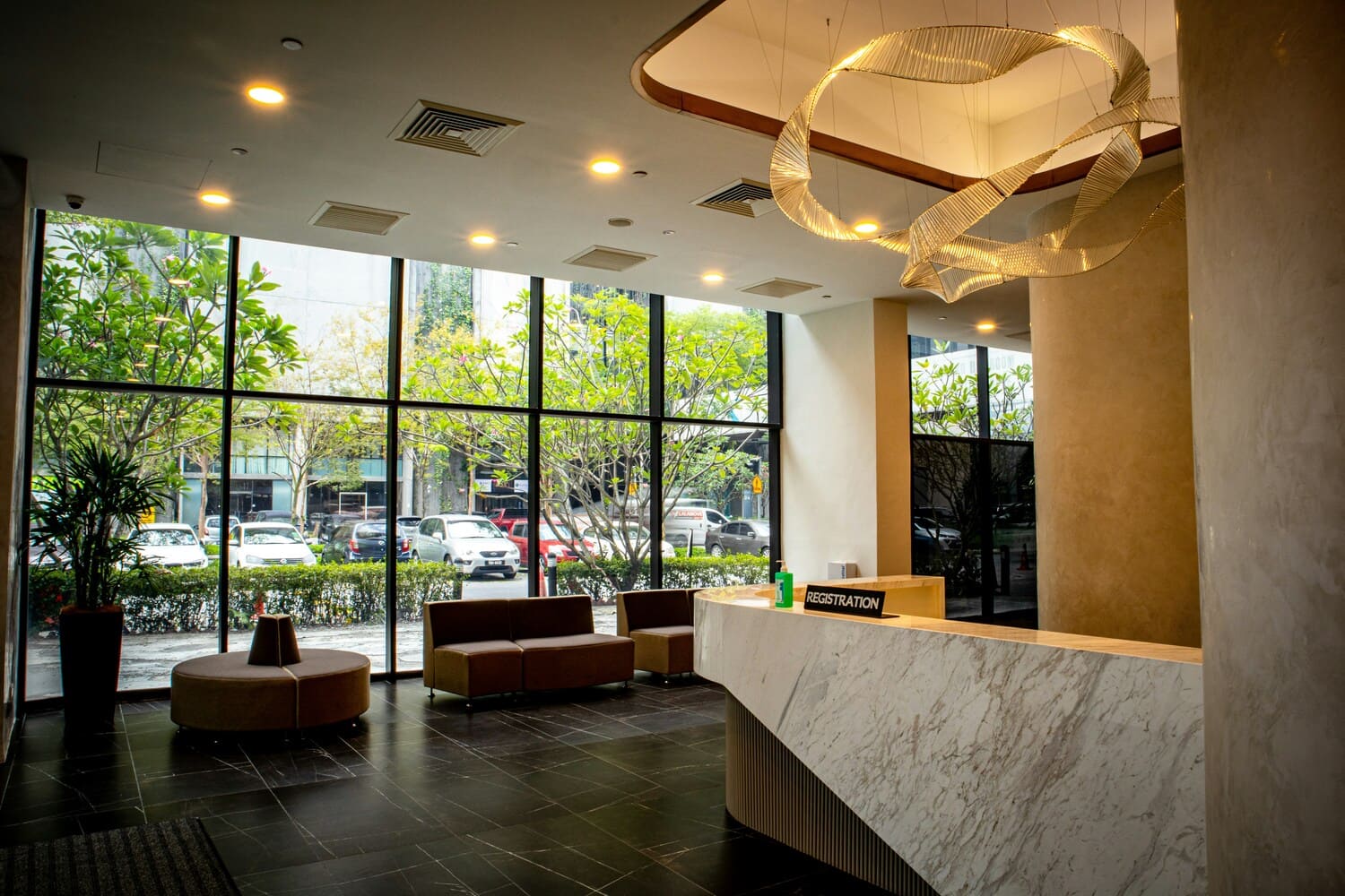 Reception area in a business center with large windows and a designer pendant light.