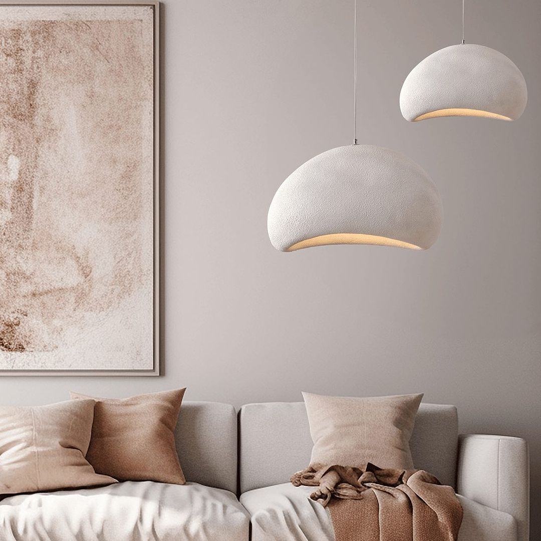 Pair of minimalist chandeliers hanging in a cozy living room, adding a touch of modern elegance.