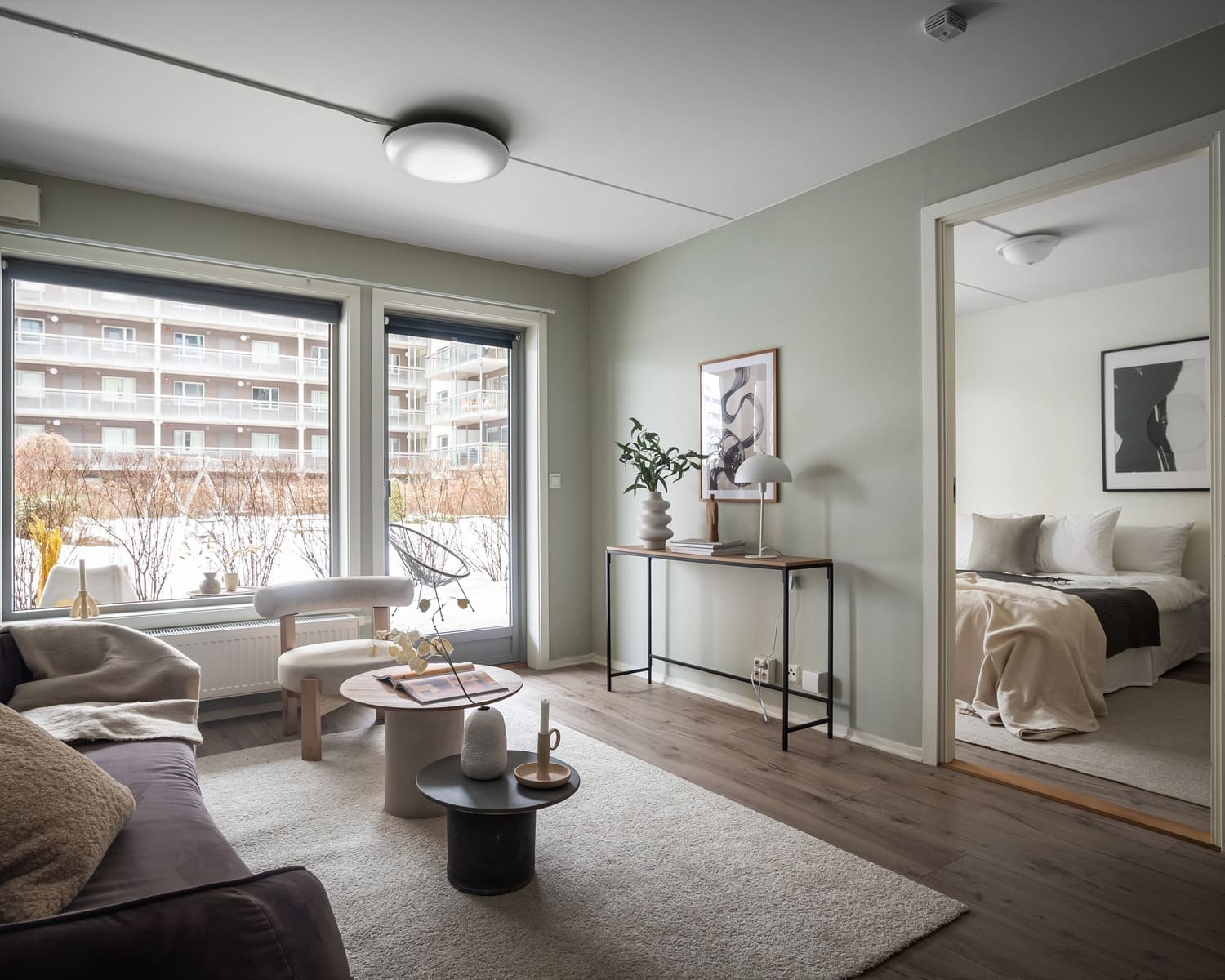 Cozy living room with a soft beige flush mount ceiling light, modern furniture, and large windows.