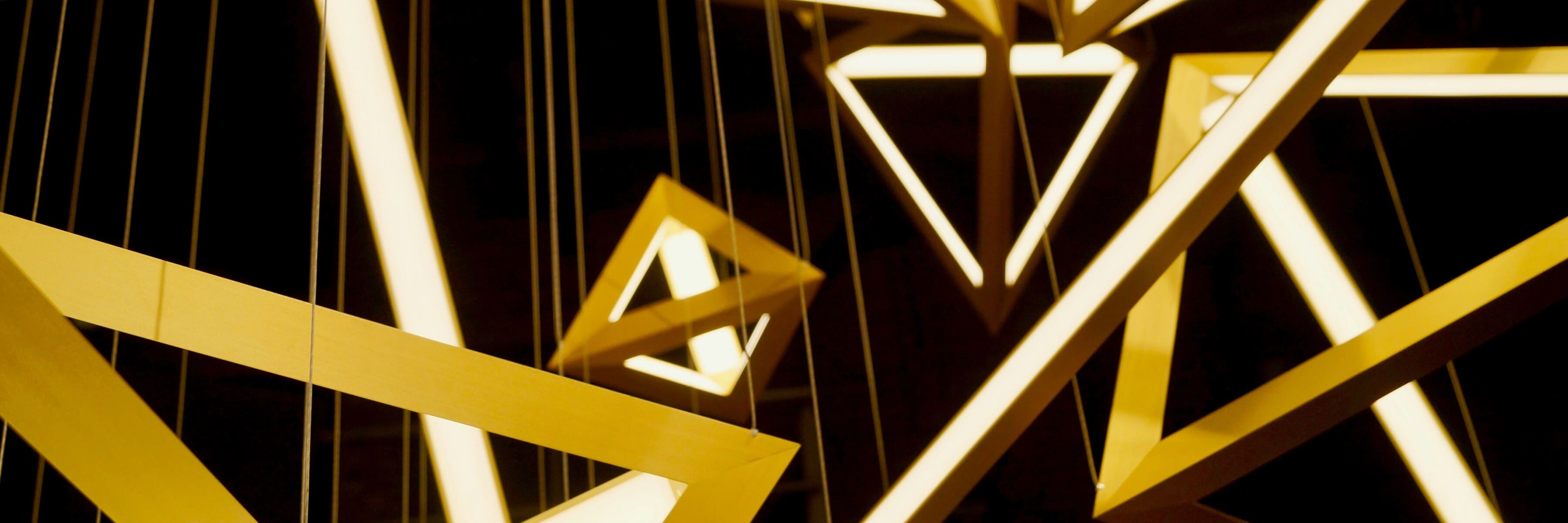 Close-up of modern geometric hanging lights with angular shapes and LED lighting, ideal for contemporary spaces.