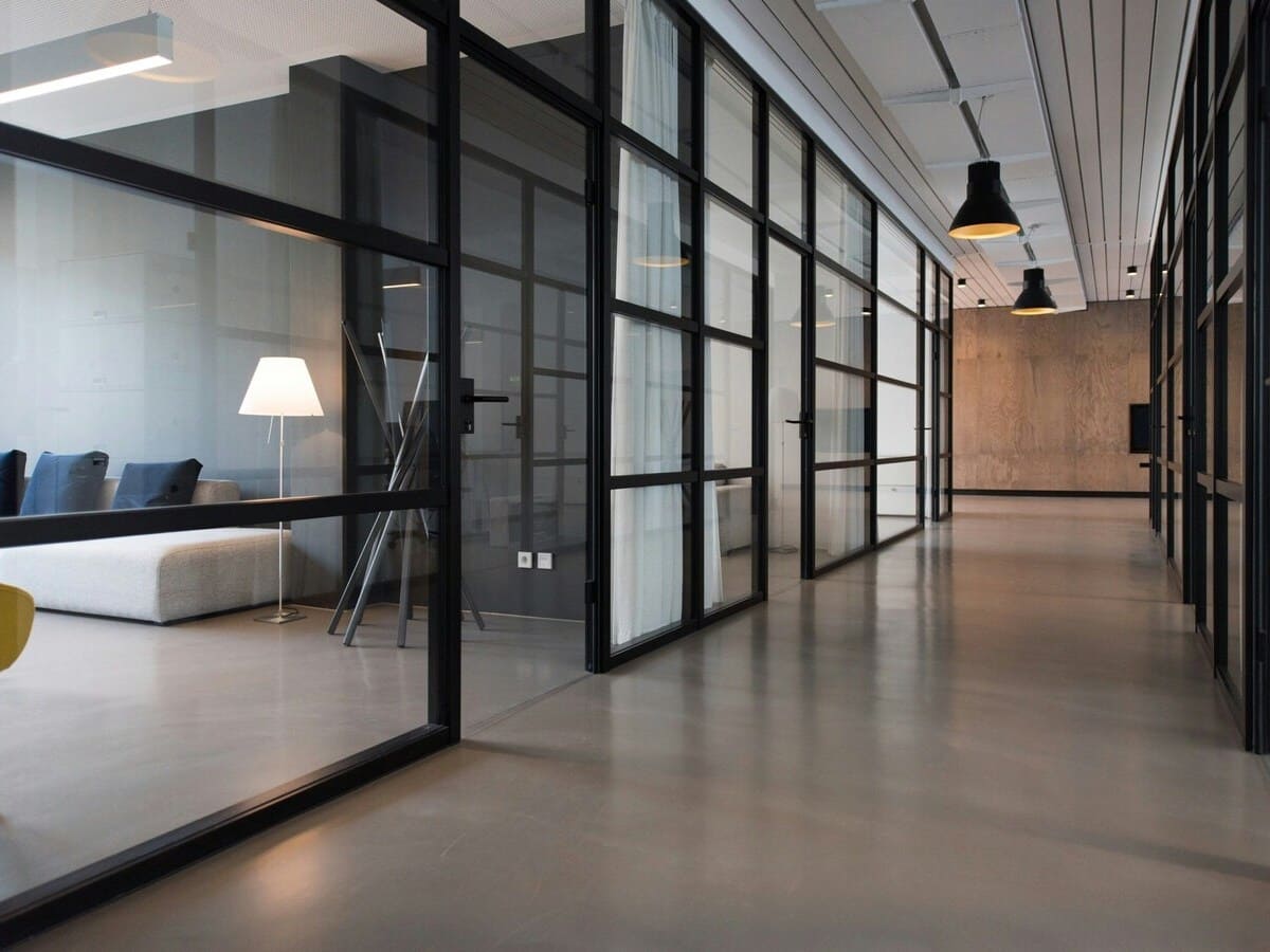 Industrial-style hallway with pendant lights and glass partition walls.