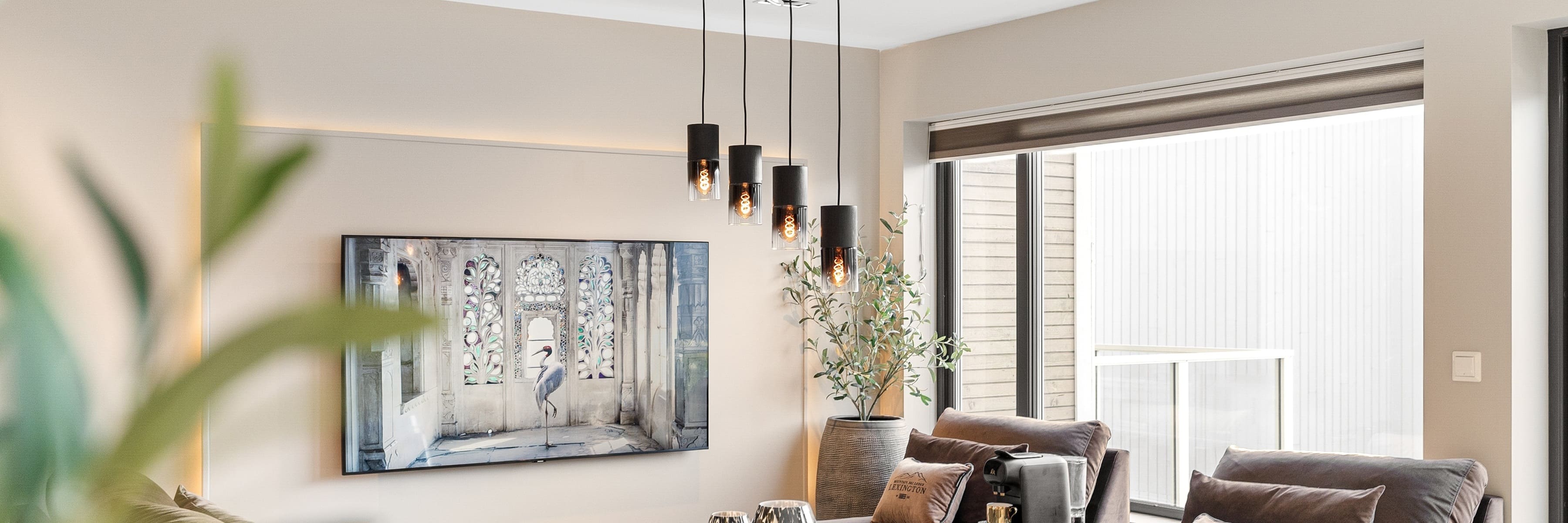 A contemporary living room featuring a cluster of black pendant lights, providing a focal point above a cozy seating area and enhancing the room's modern aesthetic.