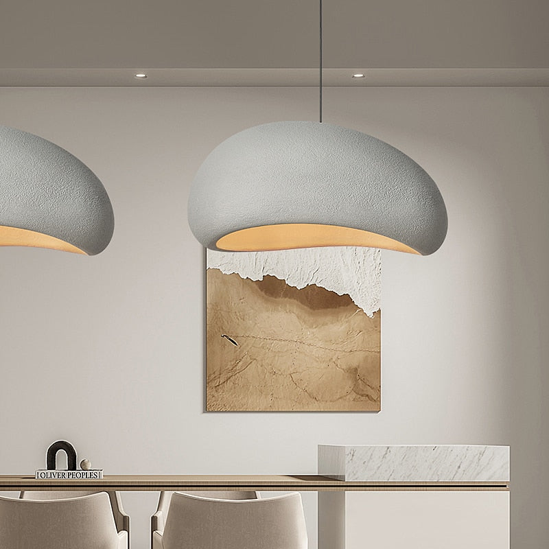 Elegant minimalist chandelier with a wabi-sabi design, featuring a smooth dome-shaped shade and soft lighting, ideal for contemporary interiors.