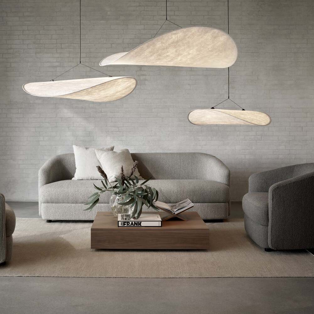 Tense Pendant Light providing soft illumination over a couch in a minimalist living room.